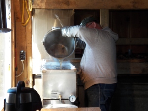 Ralph pours hot syrup, just off the evaporator, into the filter/canner